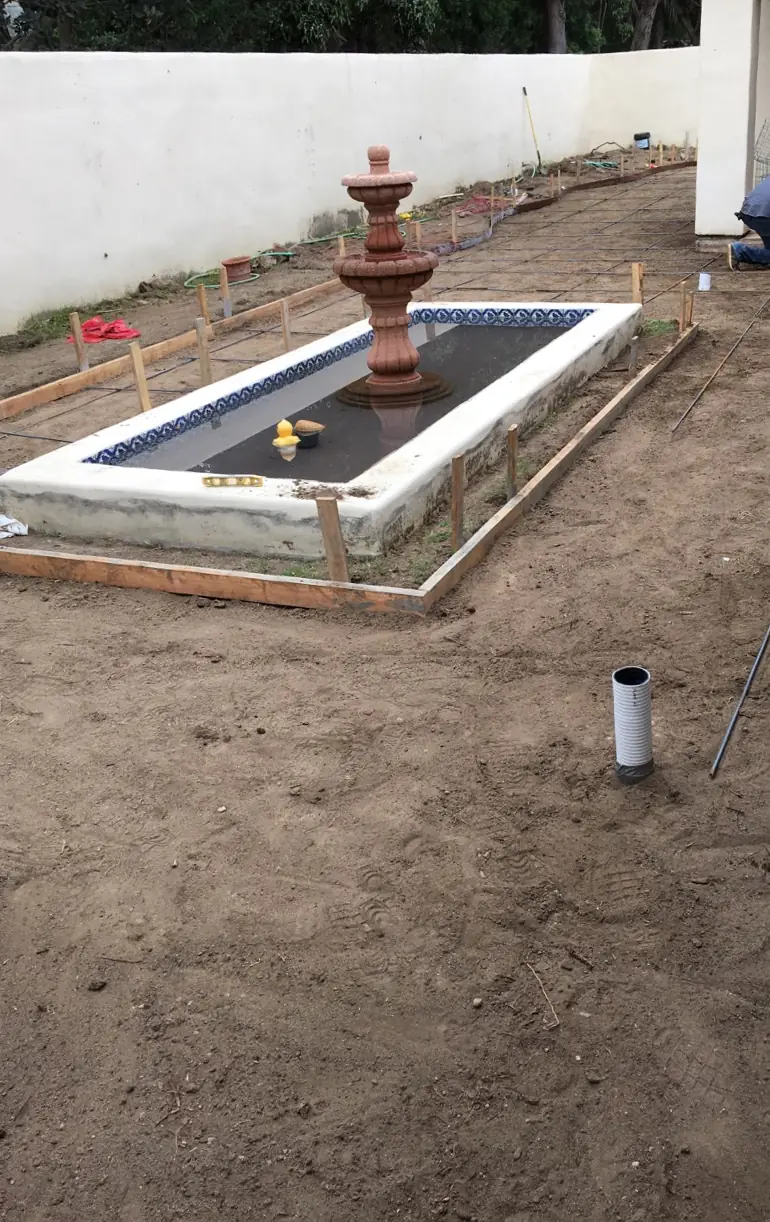 Before: a bare dirt yard with the fountain basin framed out