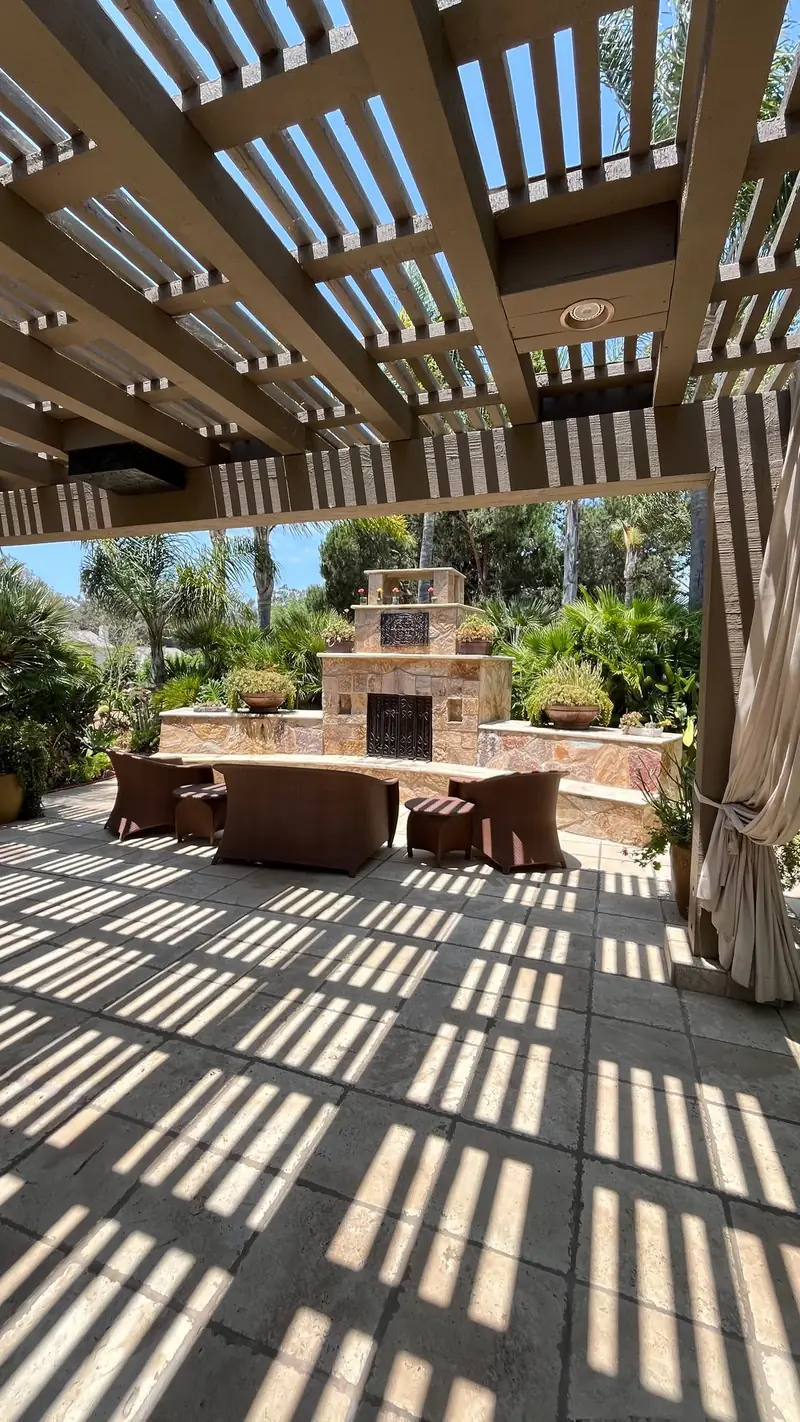 A pergola over a stone fireplace
